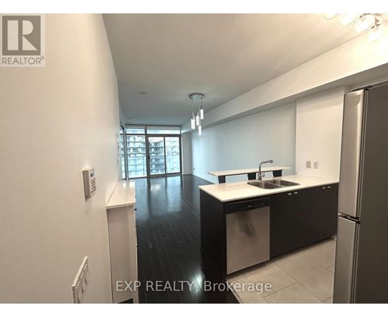 A kitchen with white cabinets and a black countertop.