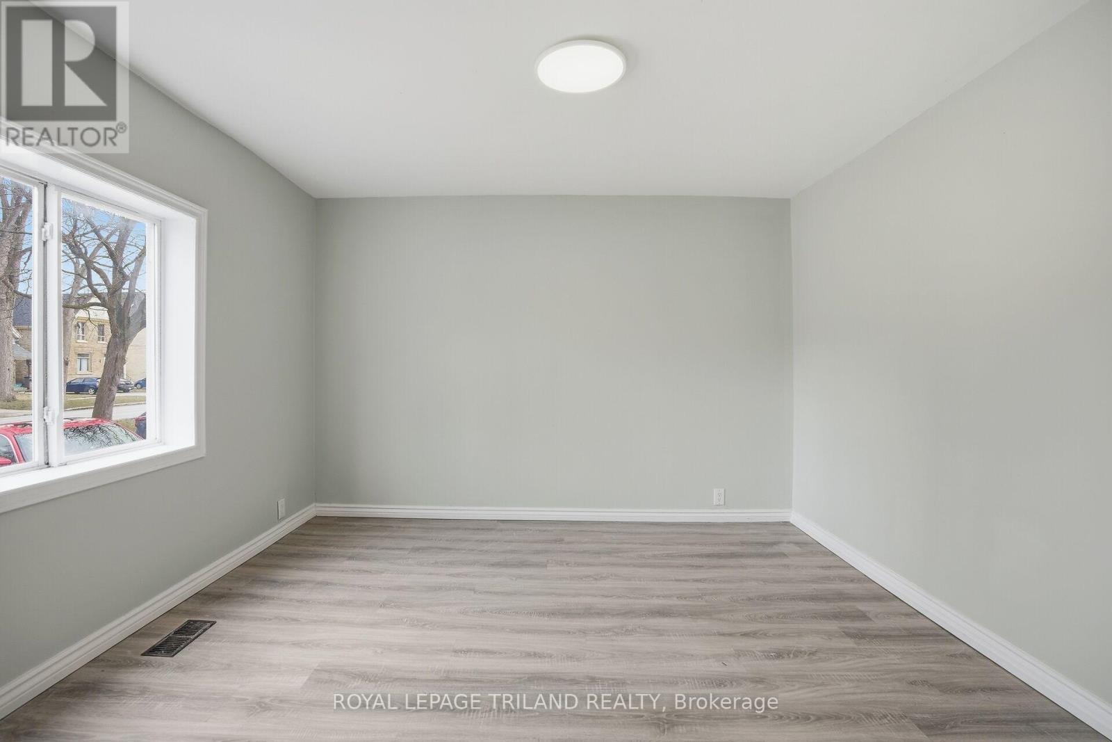 A room with a window and wooden flooring.