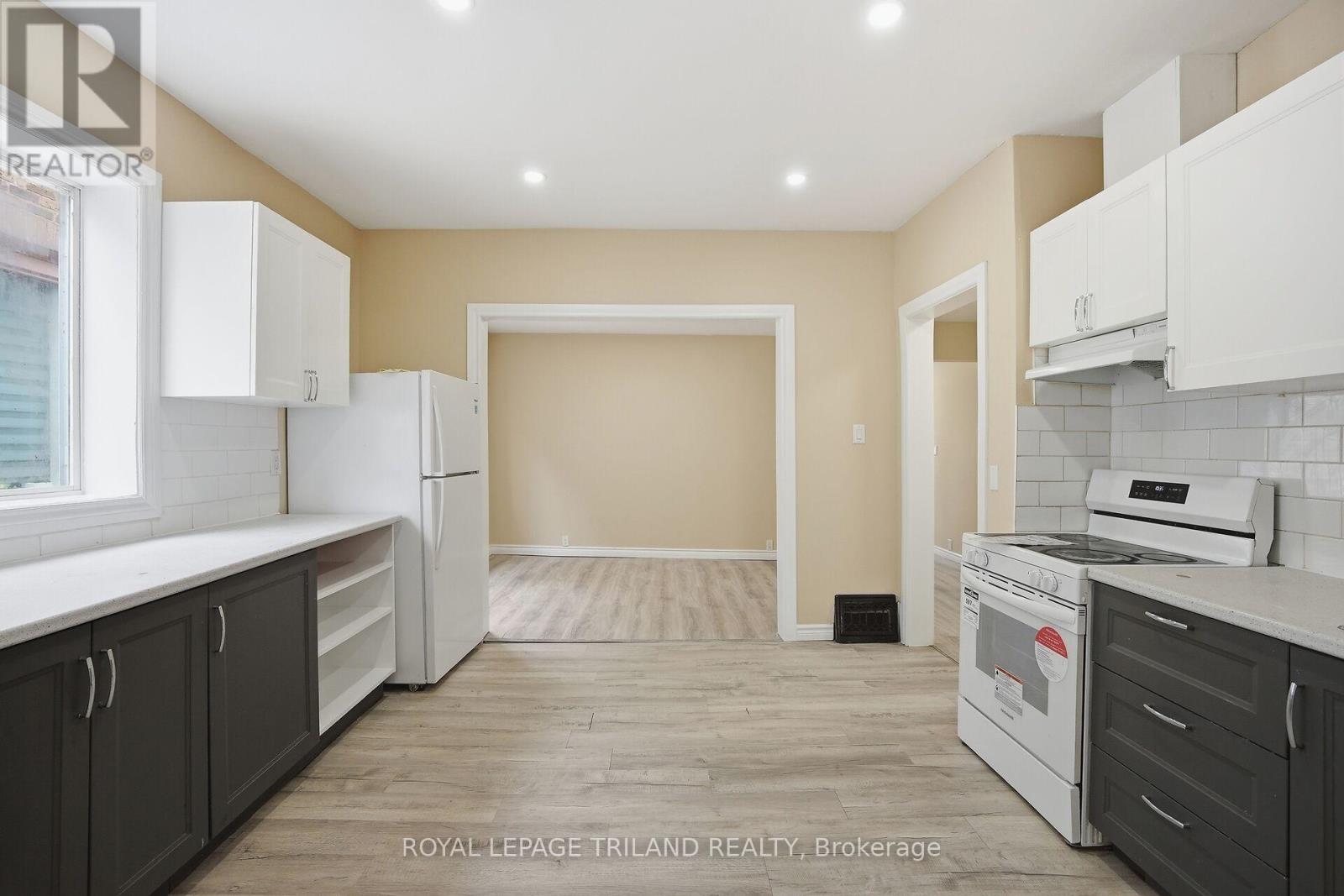 A kitchen with white appliances and black cabinets.