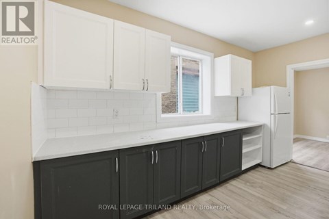 A kitchen with white cabinets and a black counter.