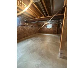 A spacious attic room with wooden beams and insulation.
