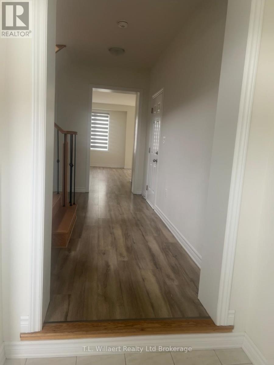 A long hallway with wood floors and white walls.