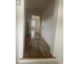 A long hallway with wood floors and white walls.