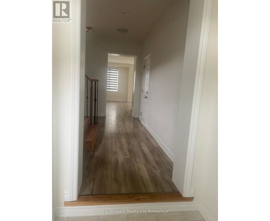 A long hallway with wood floors and white walls.