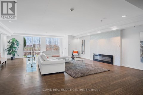 A spacious living room with a white sofa and a fireplace.