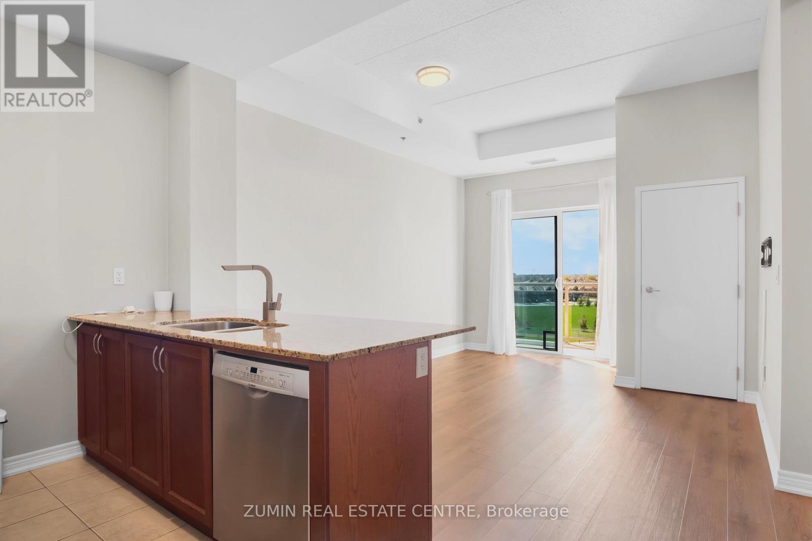 A kitchen with brown cabinets and a white sink.