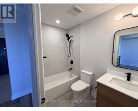A bathroom with a toilet, sink, and bathtub.
