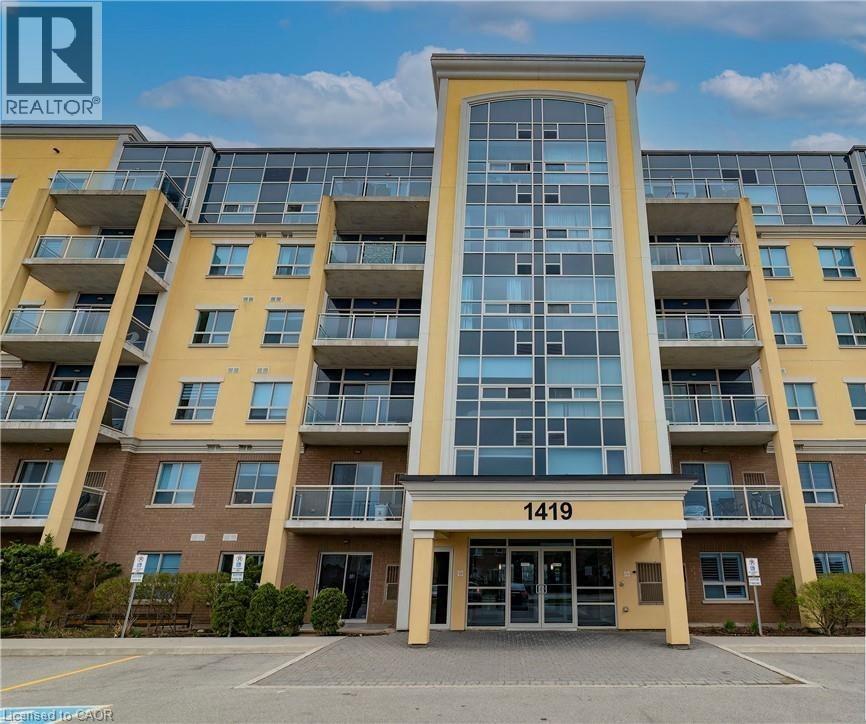 The building in the image is a large apartment complex with a glass facade and a yellow exterior.