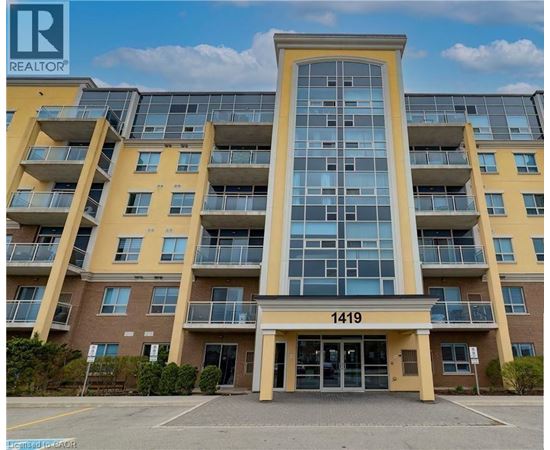 The building in the image is a large apartment complex with a glass facade and a yellow exterior.