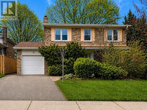 A house with a garage and a tree in front.