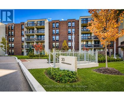 A street view of a residential area with apartment buildings and a sign that reads "20 BAY STREET GROUP INC. Brokerage".