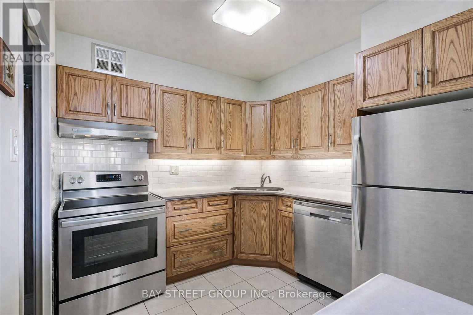A kitchen with wooden cabinets and stainless steel appliances.