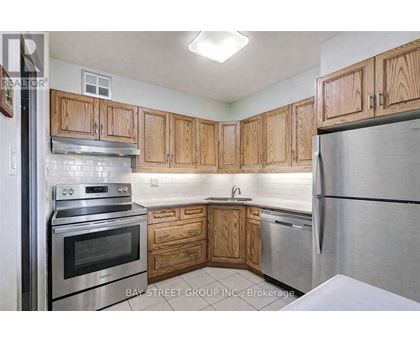 A kitchen with wooden cabinets and stainless steel appliances.