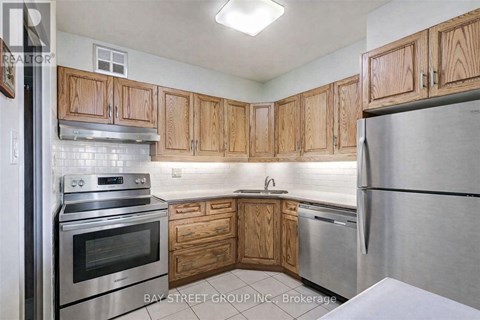 A kitchen with wooden cabinets and stainless steel appliances.