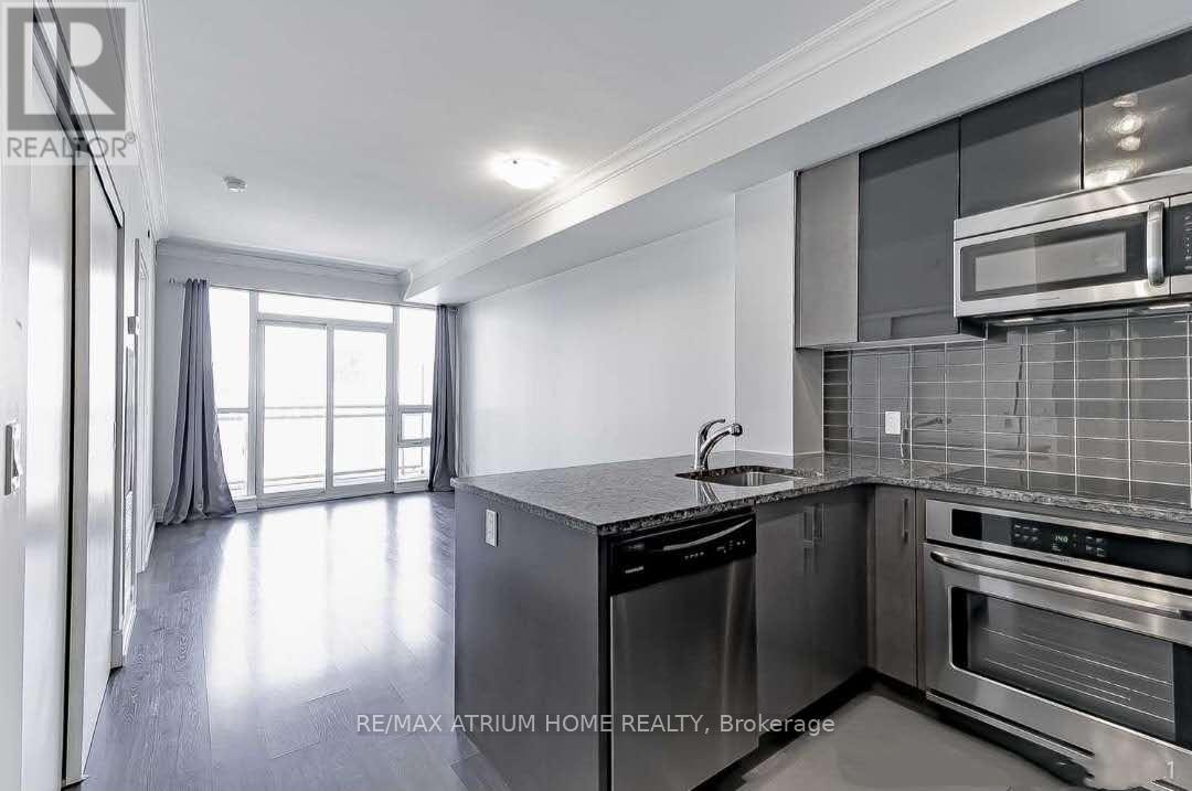 A modern kitchen with stainless steel appliances and a large window.
