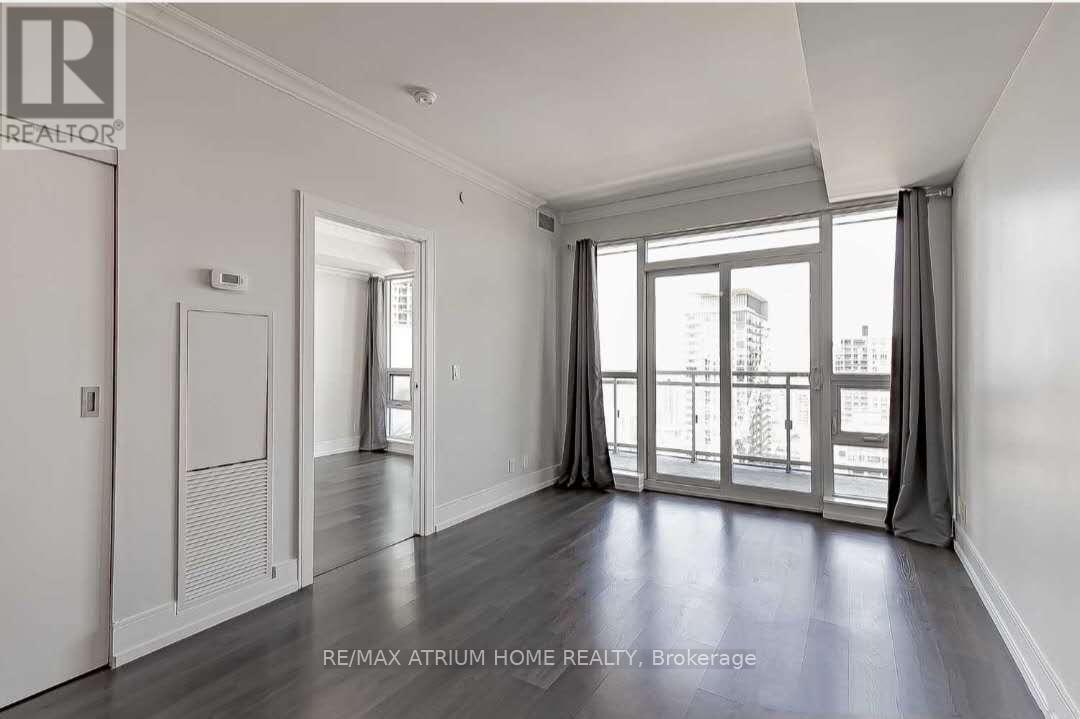 A spacious room with a sliding glass door leading to a balcony.