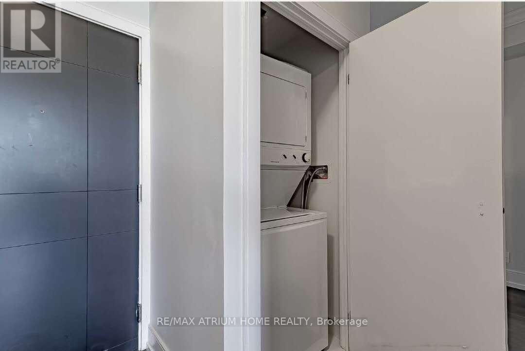A white refrigerator is in a kitchen with a grey door.