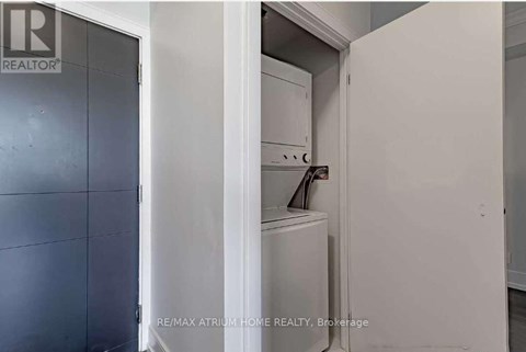 A white refrigerator is in a kitchen with a grey door.