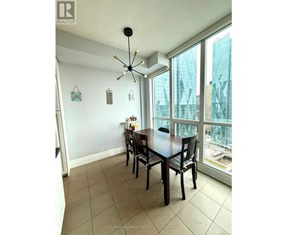 A dining room with a table and chairs and a ceiling fan.