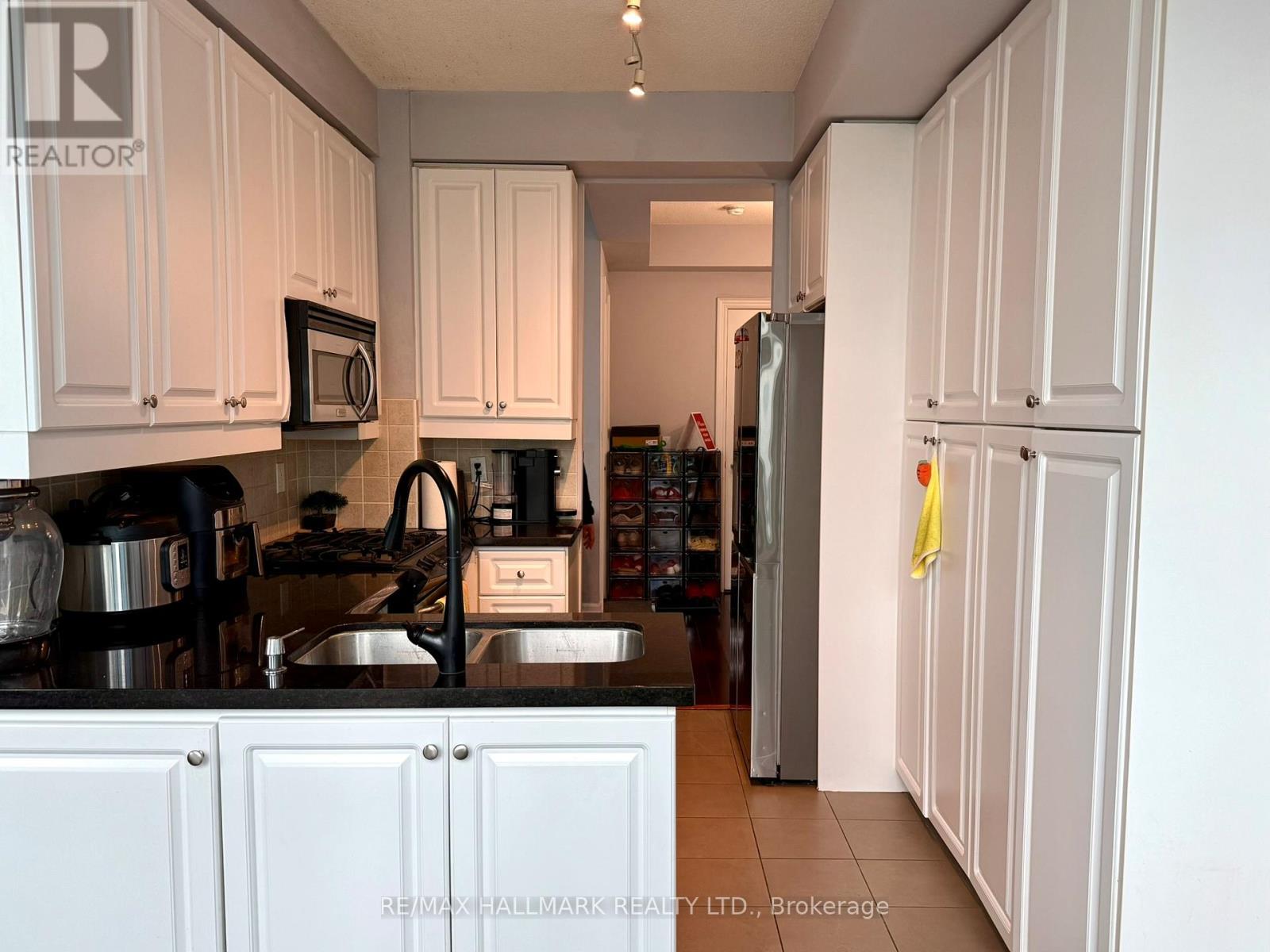 A kitchen with white cabinets and a black stove top.