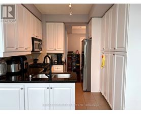 A kitchen with white cabinets and a black stove top.