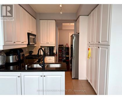 A kitchen with white cabinets and a black stove top.