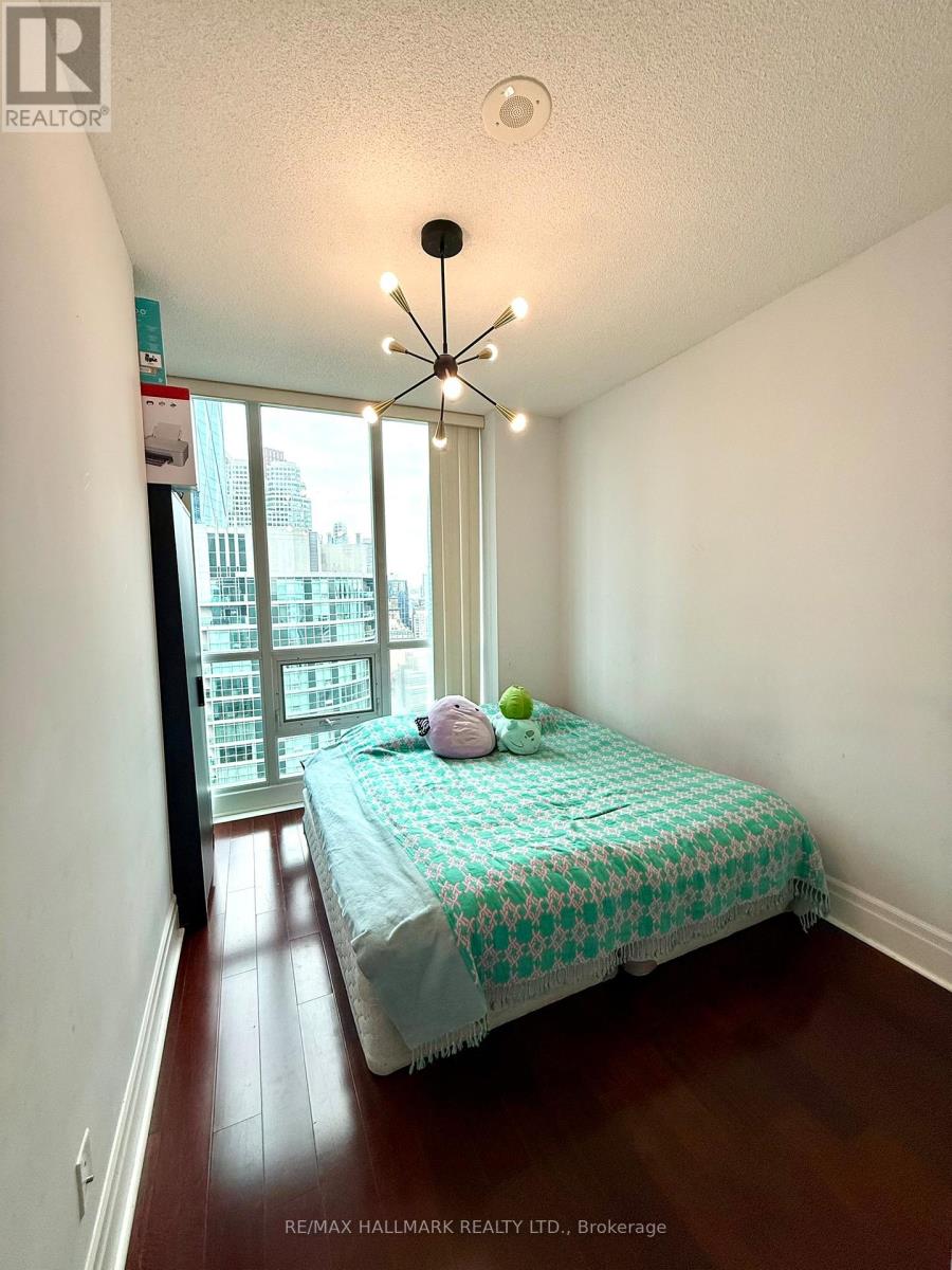 A bedroom with a bed and a window overlooking a city.