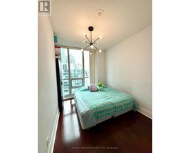 A bedroom with a bed and a window overlooking a city.