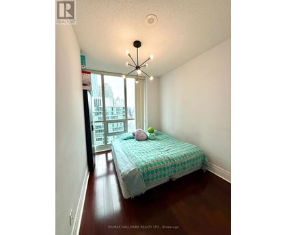 A bedroom with a bed and a window overlooking a city.