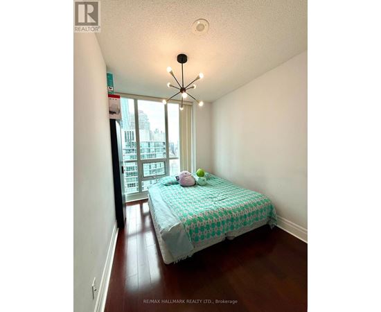 A bedroom with a bed and a window overlooking a city.