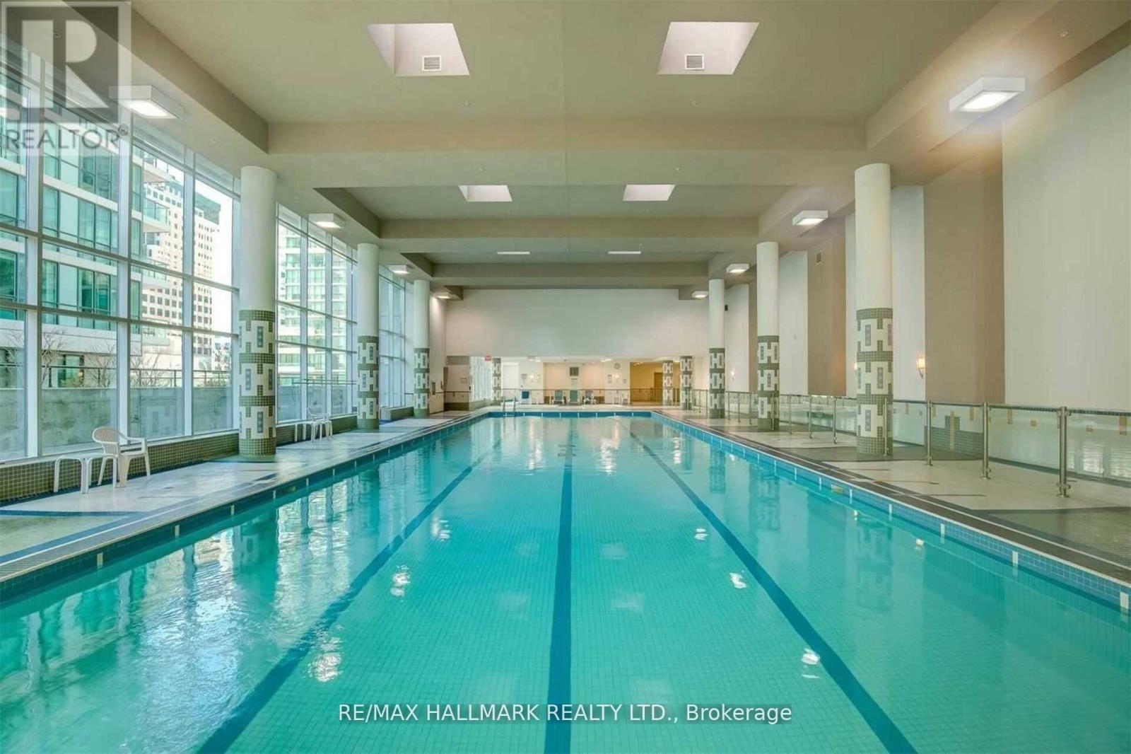 A large indoor swimming pool with a glass wall on one side.