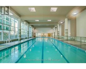 A large indoor swimming pool with a glass wall on one side.