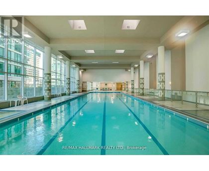 A large indoor swimming pool with a glass wall on one side.