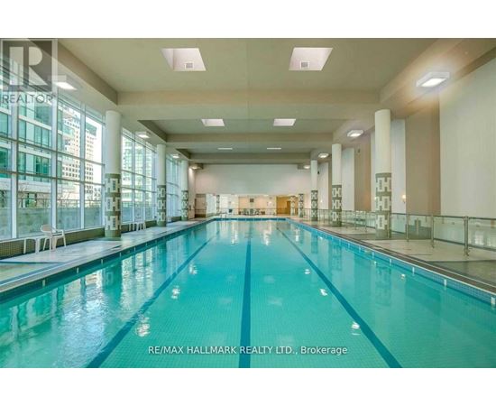 A large indoor swimming pool with a glass wall on one side.