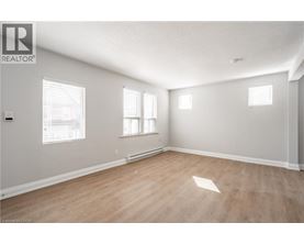 A room with wooden flooring and white walls.