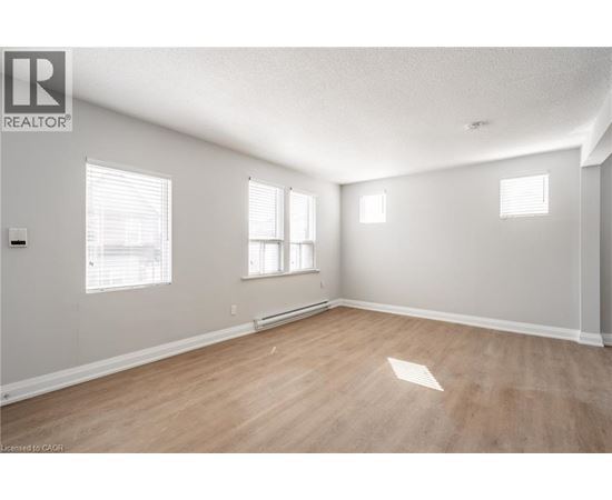 A room with wooden flooring and white walls.
