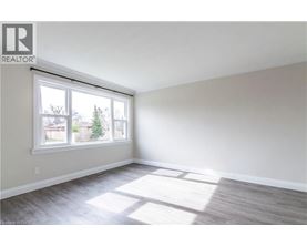 A room with a large window and a wooden floor.