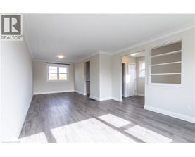A spacious room with a slanted ceiling and hardwood floors.