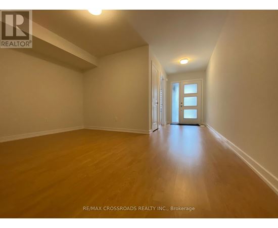 A long hallway with wood floors and white walls.