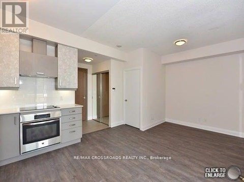 A spacious kitchen with white cabinets and a stainless steel oven.