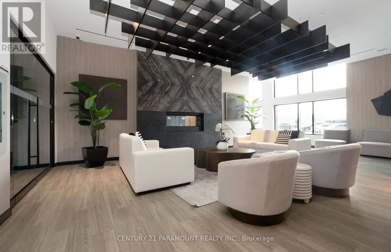 A modern living room with white furniture and a wooden floor.