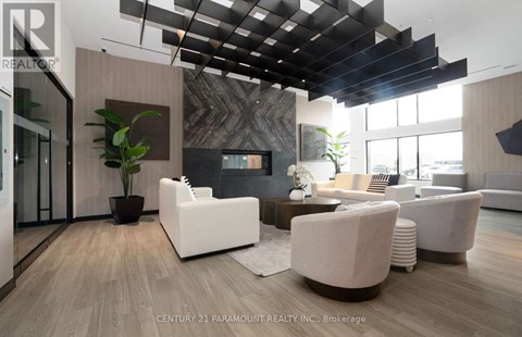 A modern living room with white furniture and a wooden floor.