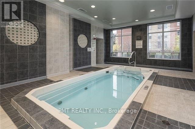 A large indoor swimming pool with a tiled wall and floor.