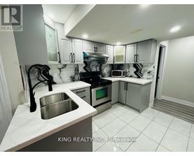 A kitchen with a sink, stove, and cabinets.