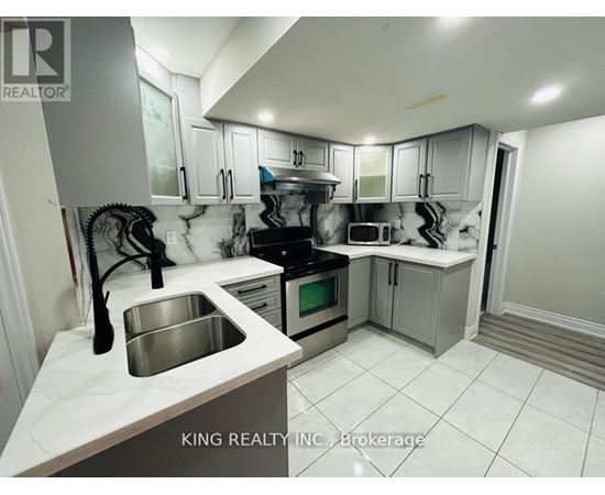 A kitchen with a sink, stove, and cabinets.
