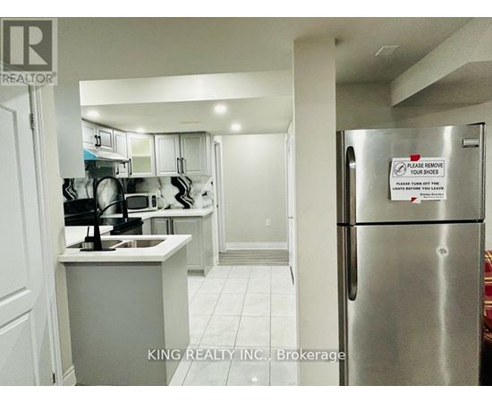 A kitchen with a refrigerator that has a sign on it.