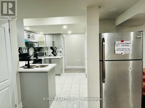 A kitchen with a refrigerator that has a sign on it.