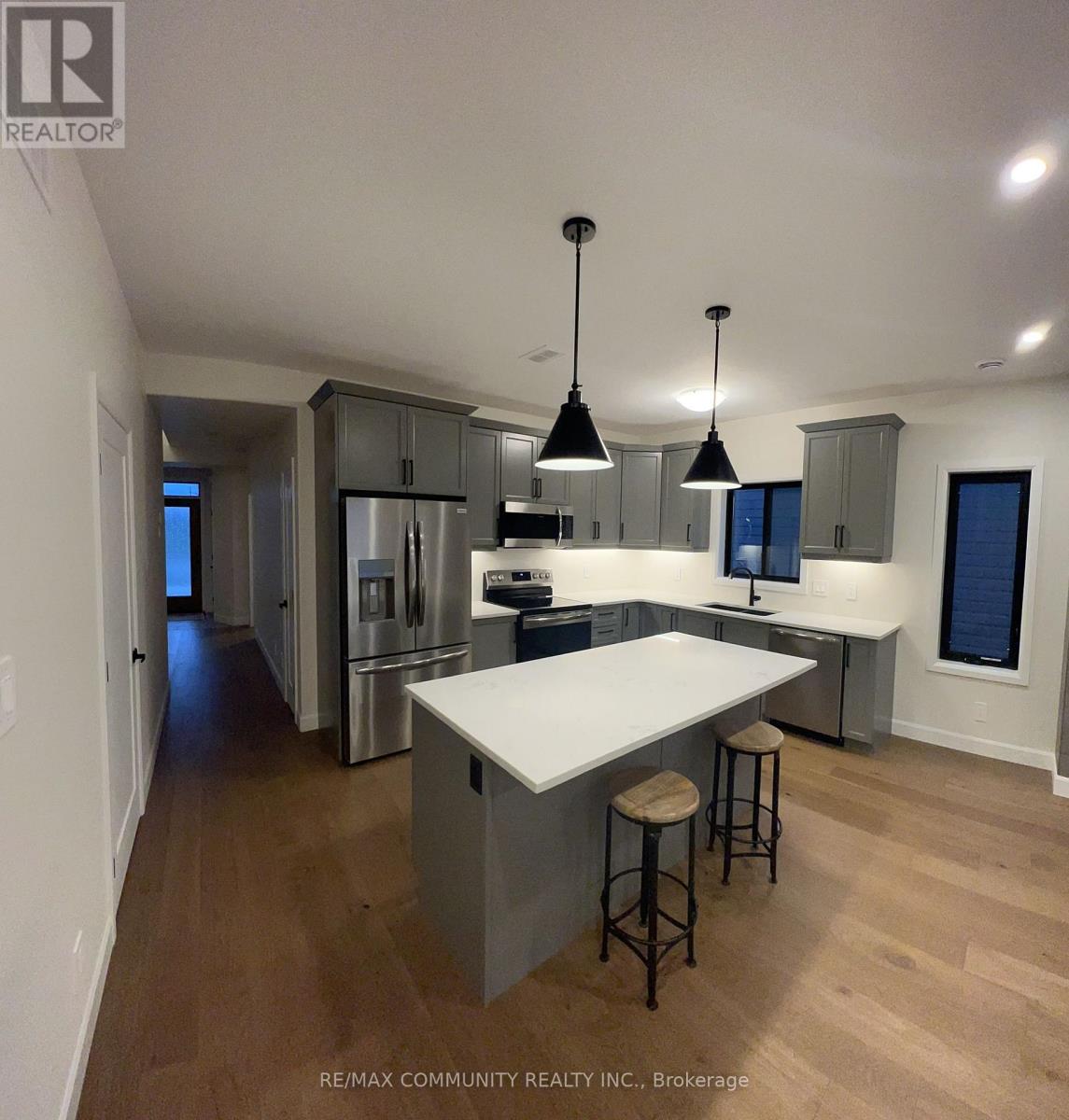 A kitchen with a white counter top and stools.