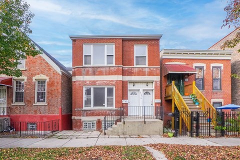 A red brick house with a white door and windows.