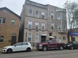 A white car is parked in front of a building.